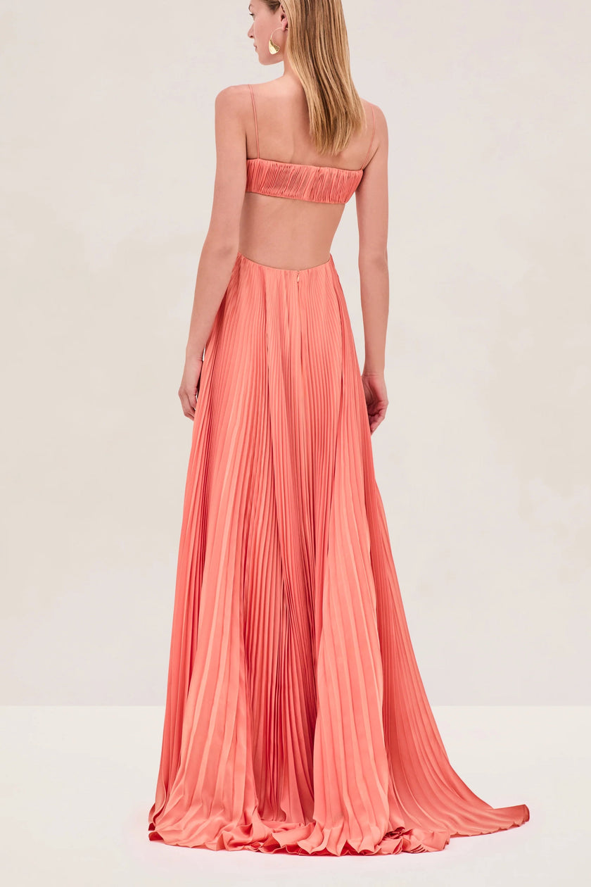 FJØRNA Sunset Varranza cutout plisse maxi dress shown on a model, featuring a vibrant sunset print and elegant cutout details.