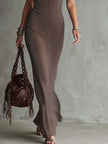 FJØRNA women's knit V-neck maxi dress displayed on a model, featuring a flowing silhouette and soft fabric in natural setting.
