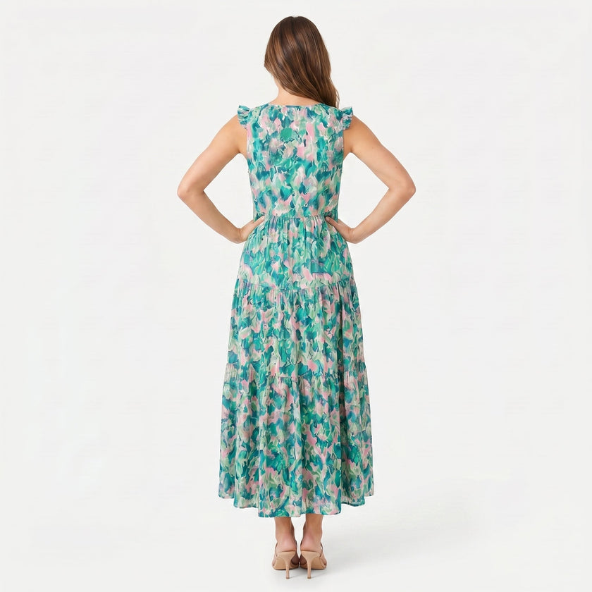 FJØRNA women's sleeveless floral print tie neck boho maxi dress displayed on a model, featuring a flowing silhouette and vibrant pattern.
