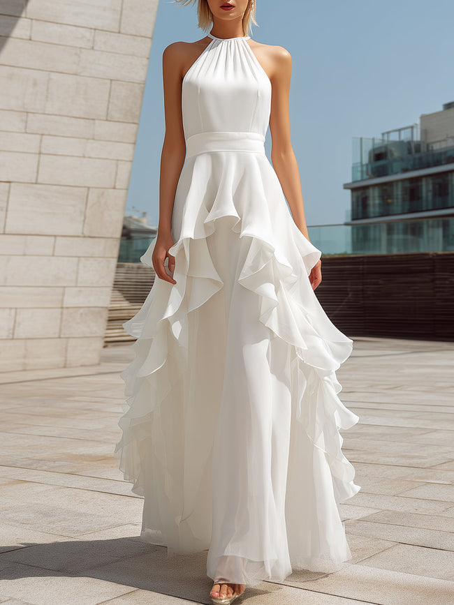 White FJØRNA halter layered ruffle maxi dress with flowing fabric and tiered ruffle details, perfect for elegant summer occasions.
