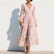 FJØRNA floral print long-sleeved V-neck pleated dress with elegant design and vibrant floral pattern on lightweight fabric.