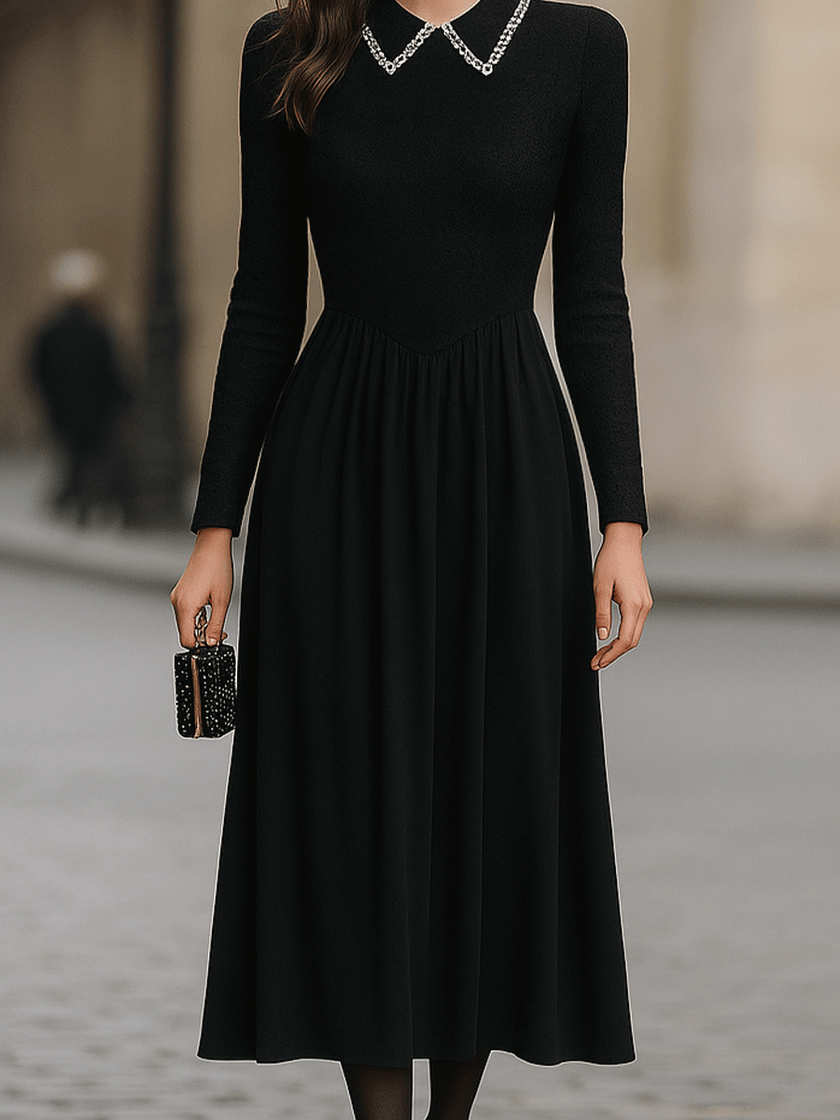 FJØRNA black long-sleeve midi dress with embellished collar, stylish and elegant, showing the dress's fitted silhouette and decorative neckline.
