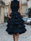 FJØRNA sleeveless high neck tiered ruffle midi dress displayed on a hanger, showcasing its elegant design and flowy fabric.
