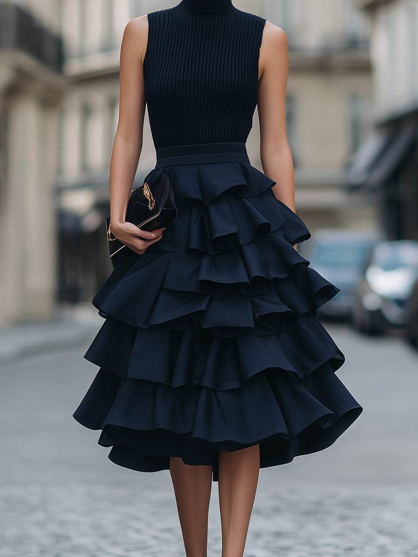 FJØRNA sleeveless high neck tiered ruffle midi dress displayed on a hanger, showcasing its elegant design and flowy fabric.