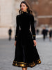 FJØRNA elegant velvet midi dress with gold trim, showcasing a fitted silhouette and luxurious fabric.