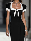 FJØRNA black and white contrast trim midi dress featuring a stylish silhouette and modern design, perfect for elegant occasions.