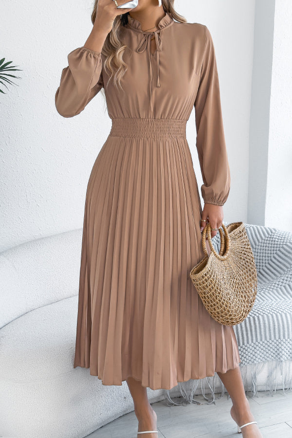 FJØRNA solid color long-sleeved fitted waist pleated midi dress displayed on a hanger, showcasing elegant design and feminine silhouette.