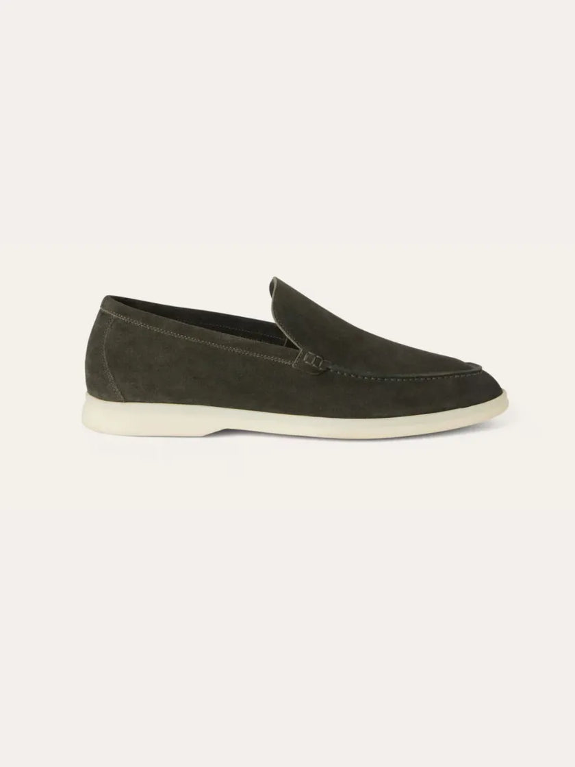 Men's dark green suede moccasin slippers by FJØRNA, shown from the side with a soft, textured suede surface and comfortable slip-on style.