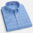 Men's FJØRNA Oxford cotton short sleeve button-up shirt displayed on a hanger, with a classic collar and button front.