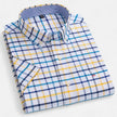 Men's FJØRNA Oxford cotton short sleeve button-up shirt with a classic collar and striped pattern, hanging on a wooden hanger.
