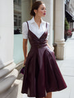 FJØRNA white button-up shirt dress with wine-red leather suspender overlay, structured fit, and long sleeves.