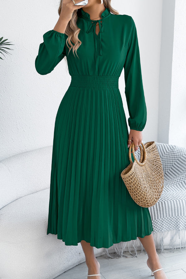 FJØRNA solid color long-sleeved fitted waist pleated elegant midi dress displayed on a model, showcasing its sophisticated design.
