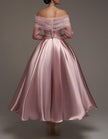 Pink satin midi dress for women by FJØRNA, strapless A-line design with shawl and strappy details, shown on a model.