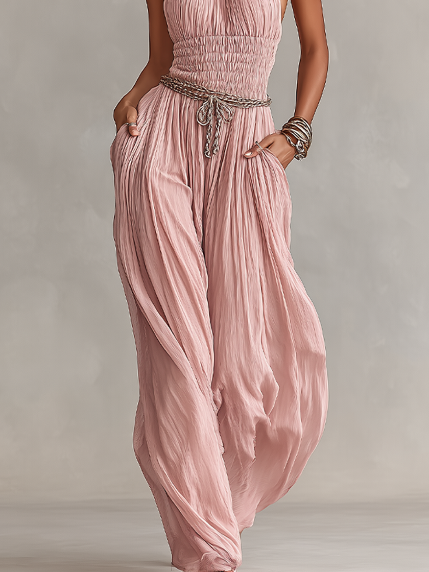 FJØRNA blush pleated jumpsuit for women featuring halter neck, ruched waist, and wide-leg pants in a stylish design