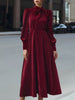 FJØRNA velvet pleated bow-neck midi dress featuring a flowy skirt and elegant bow detail at the neckline.