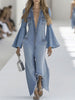 Light blue denim flared long sleeve jumpsuit by FJØRNA with wide-leg design and fitted waist, shown on a model.