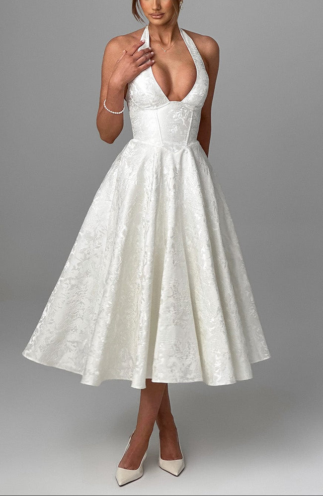 FJØRNA Bruna wedding guest halter midi dress in navy, elegant sleeveless dress with a fitted waist and flowing skirt.