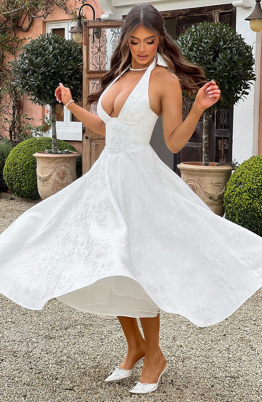 FJØRNA Bruna navy halter midi dress with fitted waist and flowy skirt, perfect for wedding guest attire.