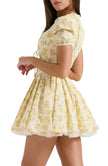 Yellow Emily Floral V-neck Corset Mini Dress by FJØRNA, showing a fitted dress with a floral pattern and V-neckline.