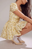 Yellow Emily Floral V-neck Corset Mini Dress by FJØRNA, featuring a fitted bodice and floral print, shown on a model.