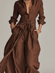 Full-body view of FJØRNA women's cotton-linen jumpsuit with shirt collar, long sleeves, wide-leg pants, and belt in brown.