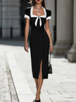 FJØRNA black and white contrast trim midi dress displayed on a model, showcasing stylish design and fitted silhouette.