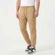 Men's slim fit cotton cargo trousers by FJØRNA, showing the beige trousers with multiple pockets and a modern, tailored fit.
