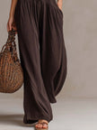 FJØRNA brown sleeveless knitted jumpsuit with ruffle neck and retro style, featuring a fitted waist and wide-leg pants.