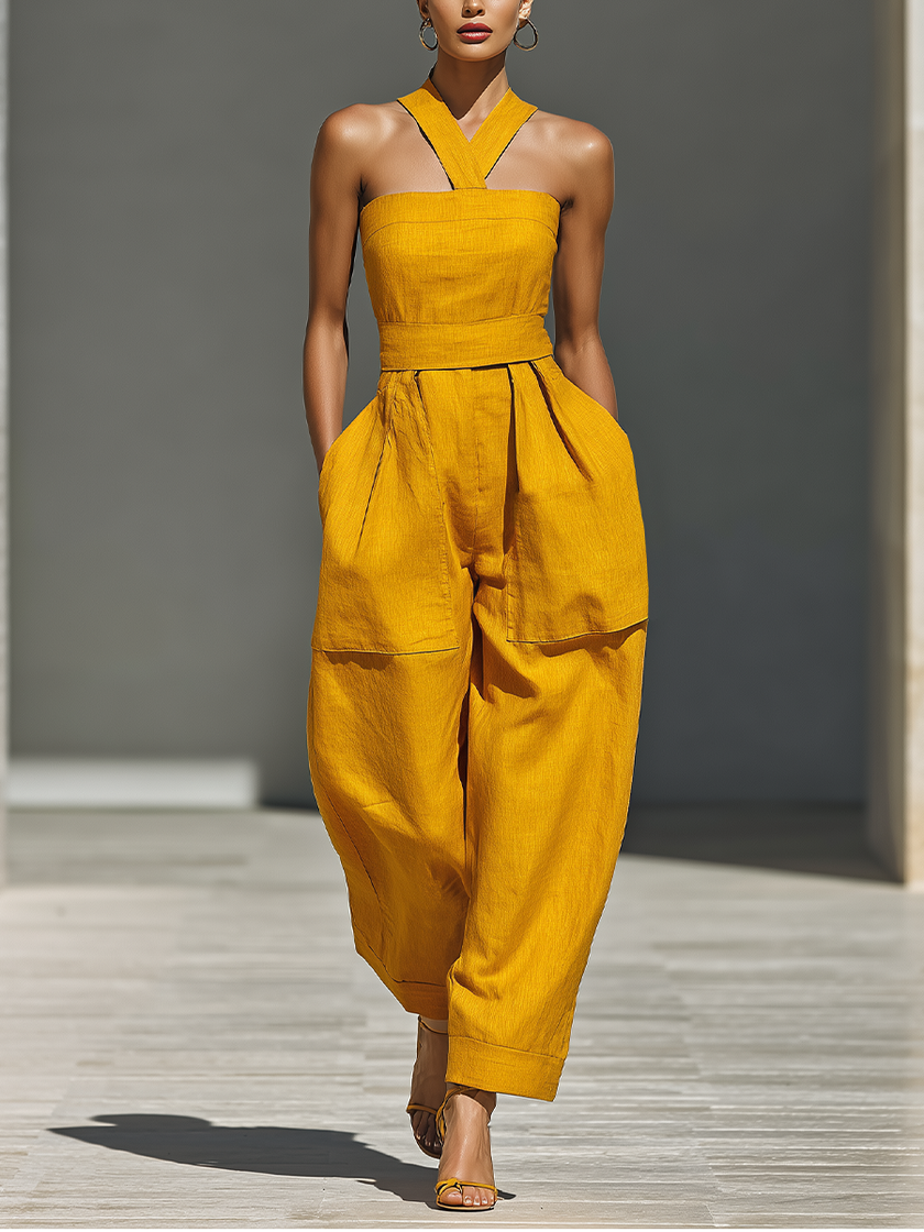 FJØRNA mustard linen-blend women's jumpsuit with crisscross neckline and relaxed wide-leg pants, styled for casual wear.