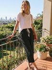 FJØRNA Felicity women's casual drawstring pants in neutral fabric, shown laid flat with relaxed fit and comfortable waistband.