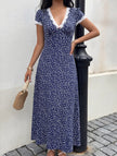 White FJØRNA lace patch floral V-neck maxi dress displayed on a hanger, showcasing its delicate lace details and flowing design.
