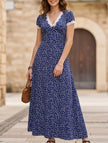 White FJØRNA lace patch floral V-neck maxi dress with intricate lace details and flowing fabric, perfect for elegant occasions.