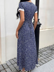 White FJØRNA lace patch floral V-neck maxi dress featuring intricate lace details and flowing fabric.