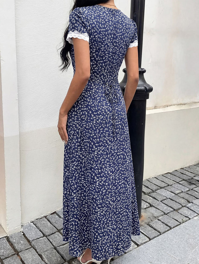 White FJØRNA lace patch floral V-neck maxi dress featuring intricate lace details and flowing fabric.