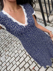 White FJØRNA lace patch floral V-neck maxi dress with intricate lace details and flowing fabric, perfect for elegant occasions.