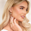 Gold FJØRNA White Quartz Heart Huggie Earrings for women, elegant jewelry with heart-shaped white quartz stones and a secure huggie design.