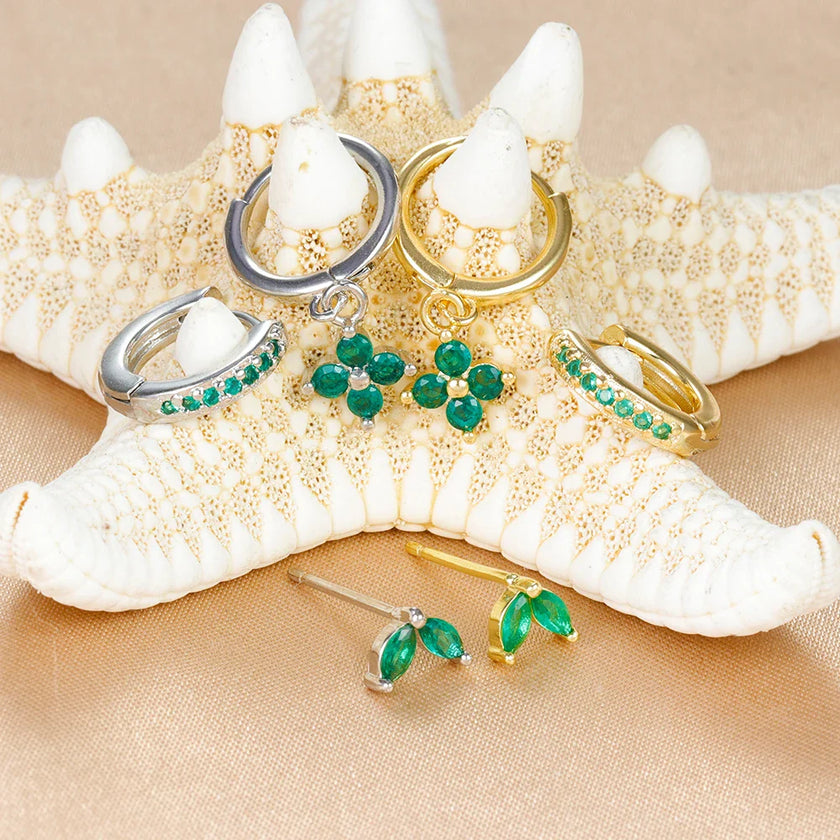 FJØRNA unisex piercing set with gold and green accessories, featuring stylish hoops and studs for effortless, all-day comfort.