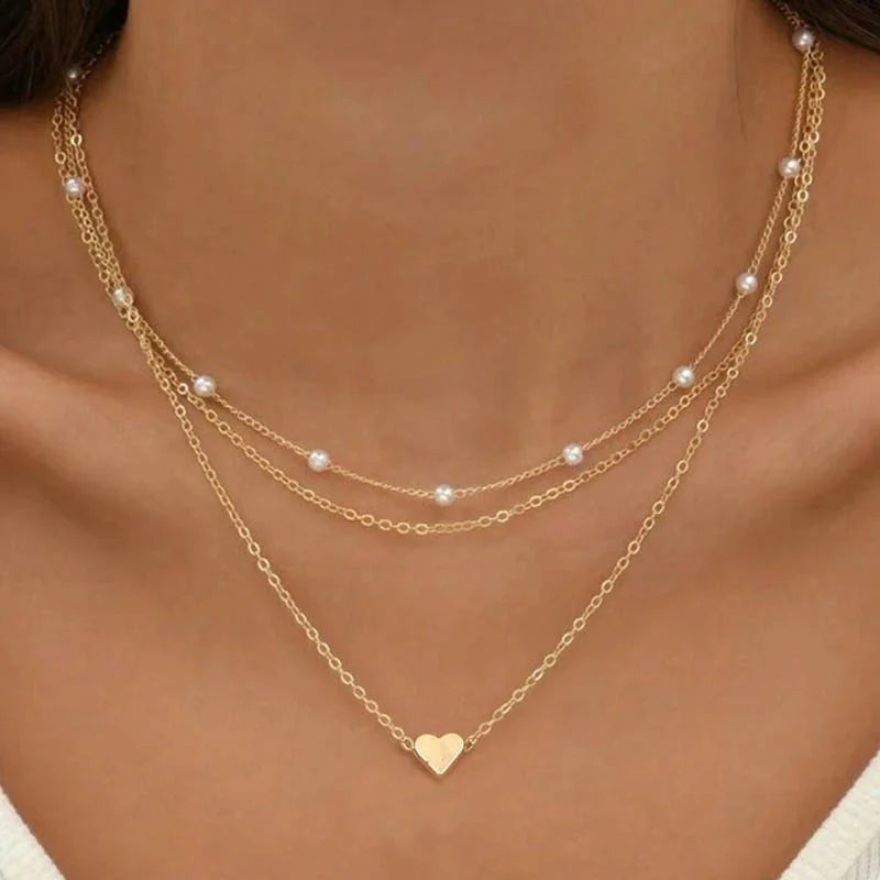 FJØRNA Lily 3-layer gold and silver necklace set with heart or cross pendant, women's accessories featuring layered chain design.