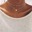 FJØRNA Lily 3-layer gold and silver necklace set for women with heart or cross pendants, showcasing layered jewelry design.