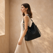 FJØRNA black faux leather hobo shoulder bag for women with spacious interior and matching pouch, vegan and stylish.