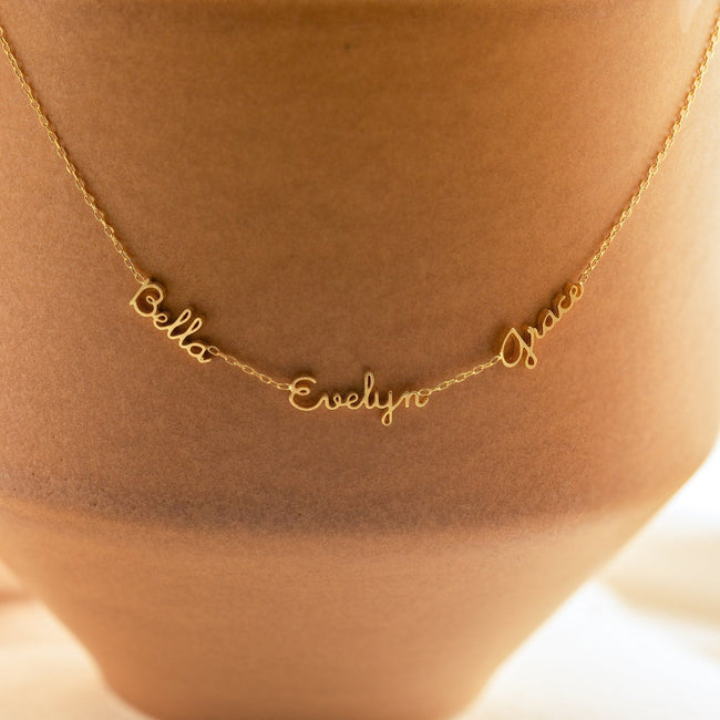 Dainty gold custom name necklace by FJØRNA featuring two or three names, 14 inches in length, elegant personal jewellery.