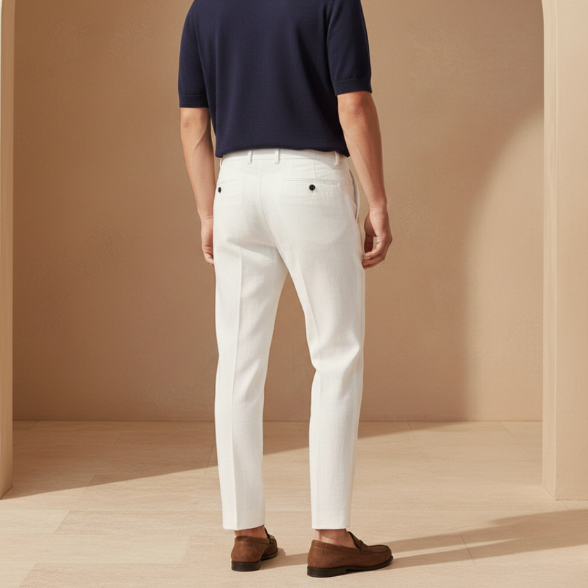 White FJØRNA linen trousers for men with a relaxed fit, casual style, suitable for comfortable everyday wear.