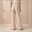 Beige high waist wide leg tailored women's pants by FJØRNA, showcasing a relaxed fit and elegant design.