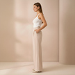 Beige high-waist wide-leg tailored pants for women by FJØRNA, featuring a relaxed fit and stylish design.