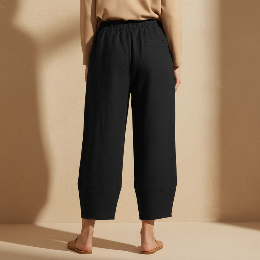 Black women's wide leg trousers by FJØRNA with elastic waist, loose fit, and cotton fabric for comfort and style.