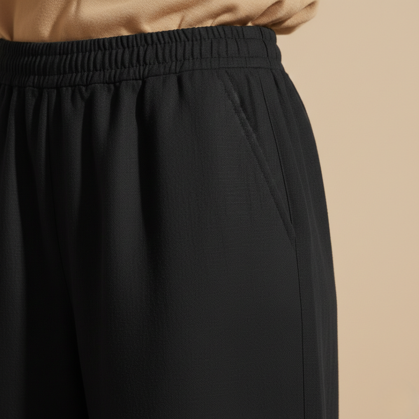 Black FJØRNA women's wide leg trousers with elastic waist, loose fit, cotton fabric, stylish and comfortable for everyday wear.