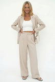 FJØRNA women's wide-leg high-waist trousers, stylish pants with a relaxed fit, shown on a model in a casual outfit.