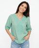 FJØRNA women's cotton V-neck blouse featuring a relaxed fit and soft fabric, displayed on a model.