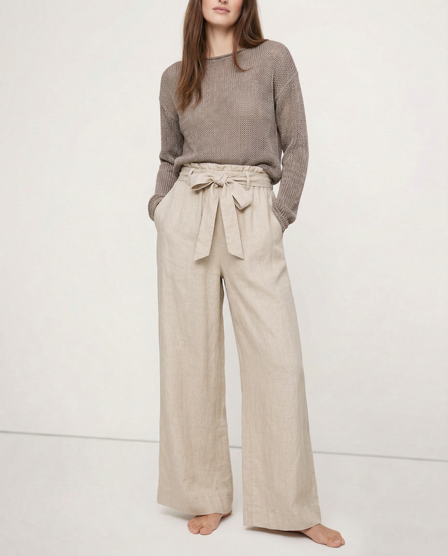 FJØRNA linen wide leg trousers for women with elastic waist and ruffle details, shown in a close-up highlighting fabric quality.
