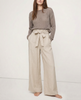 FJØRNA linen wide leg trousers for women with elastic waist and ruffle details, shown in a close-up highlighting fabric quality.